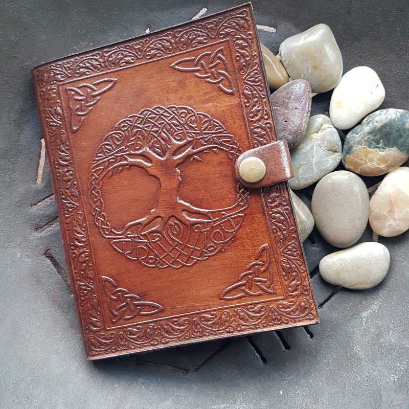 Brown leather bound journal and blank page book. Hand embossed cover design of Tree with roots and branches. Celtic tree of life.